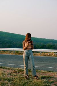 Woman standing on field against clear sky