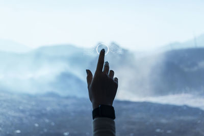 Person with arms raised against sky