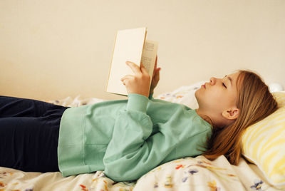 High angle view of mother and daughter sitting on bed at home