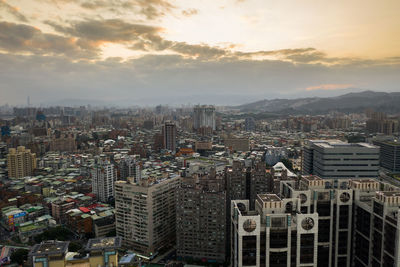 High angle view of modern buildings in city against sky during sunset