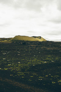 Scenic view of landscape against cloudy sky