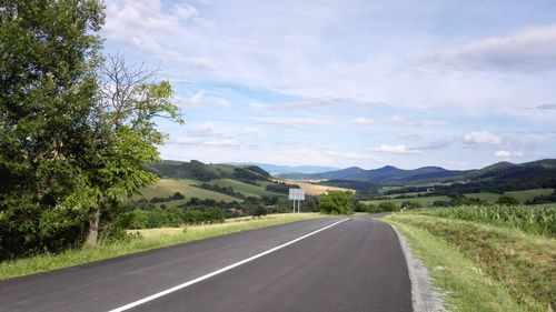 Road by landscape against sky