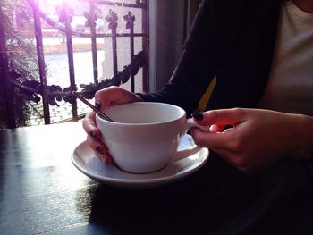 Close-up mid section of a woman drinking coffee