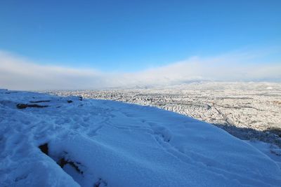 Scenic view of snow covered landscape against blue sky