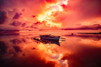 Silhouette boat in sea against sky during sunset