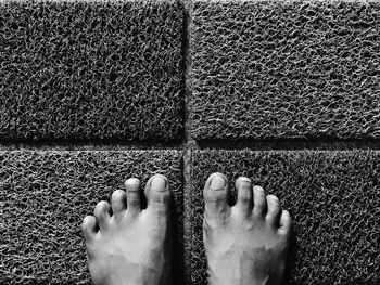 Low section of man standing on doormat