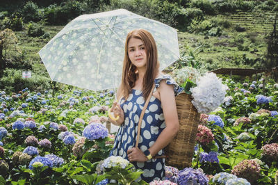 Beautiful young woman against white flowering plants