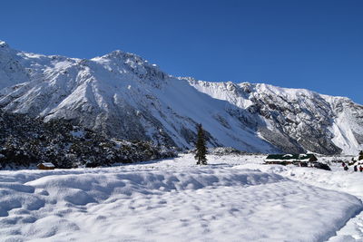 Snow covered mountains against clear blue sky