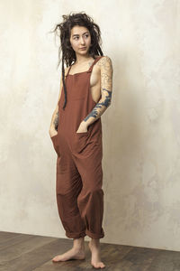 Portrait of woman standing against wall