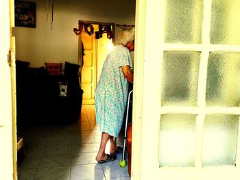 Rear view of man standing by door at home