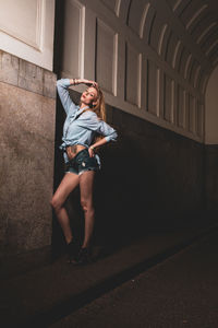 Full length of woman standing against building