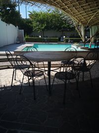 Empty chairs and tables in swimming pool