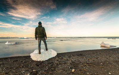 Man standing over a block of ice