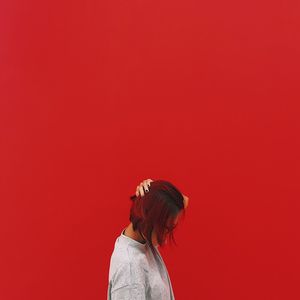 Woman standing against red background