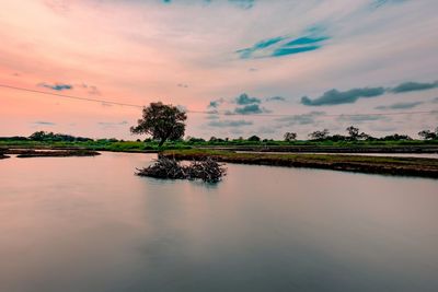 Scenic view of lake against sky at sunset