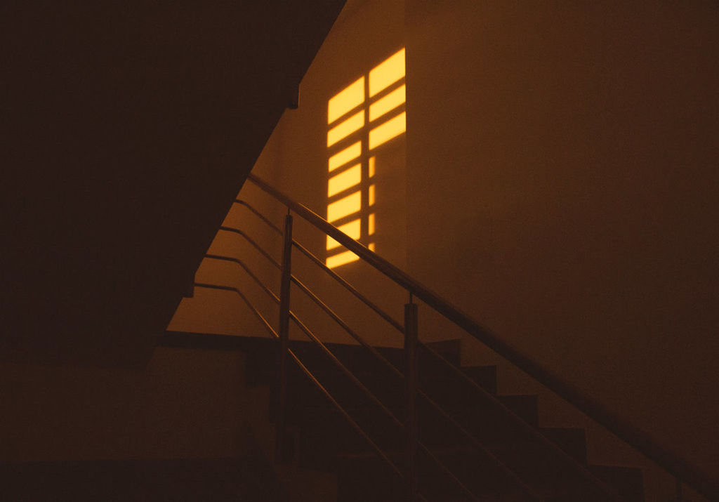 LOW ANGLE VIEW OF ILLUMINATED STAIRCASE IN DARKROOM