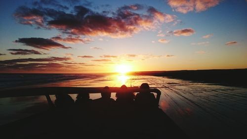 Silhouette people at beach during sunset