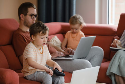 Big happy family watching movies playing games on laptop. mother father kids spending time with
