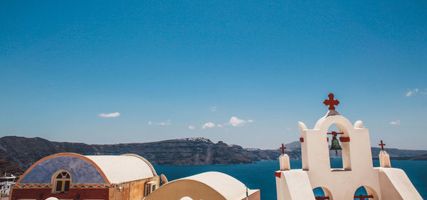 High section of church by sea against blue sky at oia