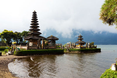 Temple by building against sky