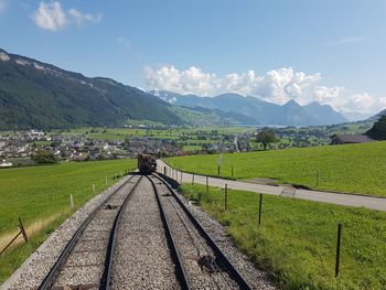 View of railroad tracks on landscape against sky