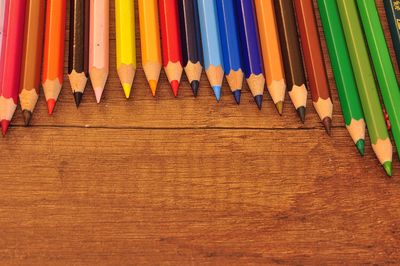 High angle view of colored pencils on wooden table