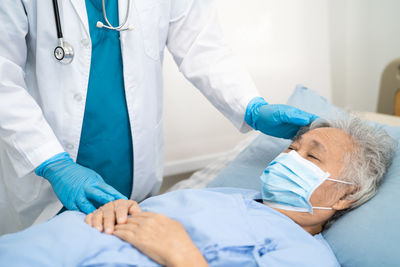 Midsection of doctor examining patient in hospital