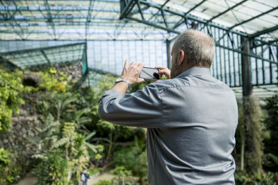 Man taking photos in glasshouse