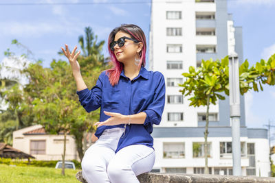 Full length of young woman against built structure