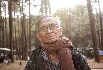 Portrait of senior man wearing scarf against trees