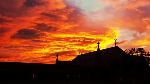 Silhouette of building against cloudy sky during sunset