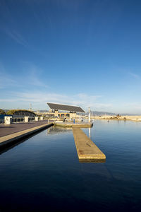 Built structure at jetty on river against blue sky