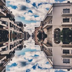 Buildings in city against cloudy sky