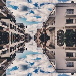 Buildings in city against cloudy sky