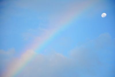 Low angle view of rainbow against blue sky