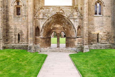 Walkway amidst field against elgin cathedral