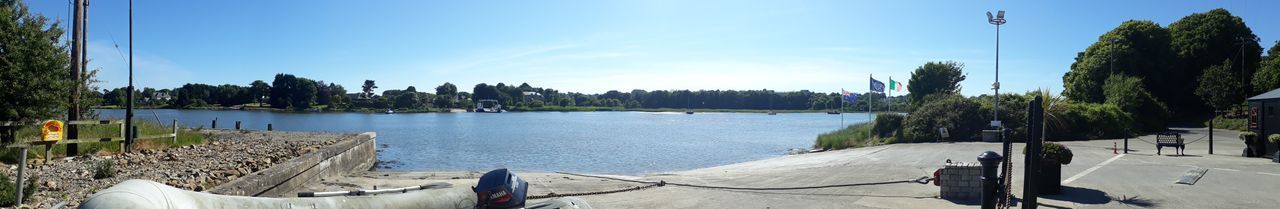 Panoramic shot of city by sea against blue sky