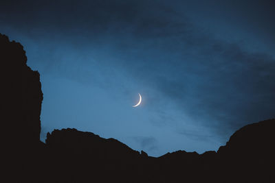 Low angle view of silhouette mountain against sky at night