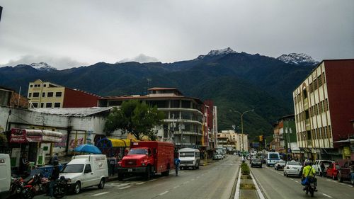 Cars on road by city against sky