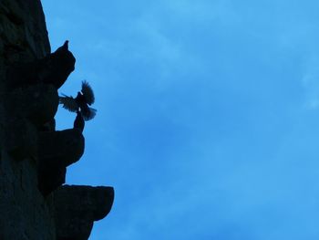 Low angle view of rock formation against blue sky
