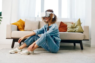 Portrait of young woman sitting on sofa at home