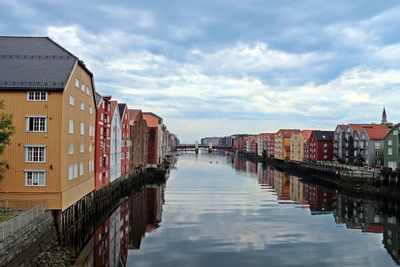 Canal amidst buildings in city against sky