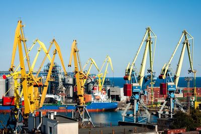 Boats in river against clear blue sky
