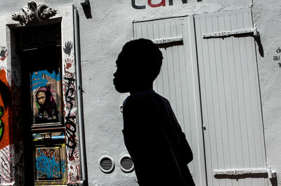 Rear view of woman standing against wall