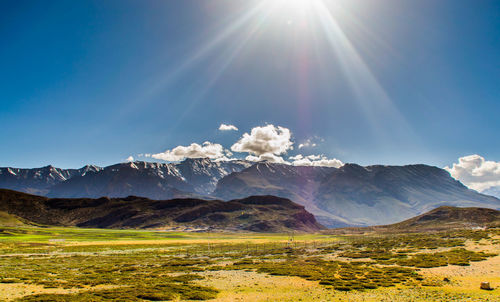 Scenic view of snowcapped mountains against sky on sunny day