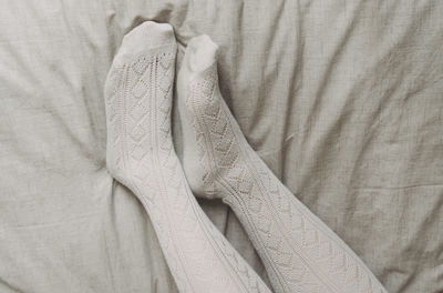 Full frame shot of legs with socks hanging on bed