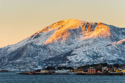 Scenic view of lake by mountains against clear sky