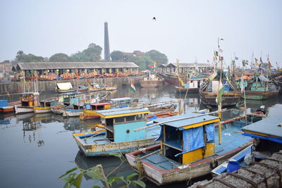 Boats moored at harbor against clear sky