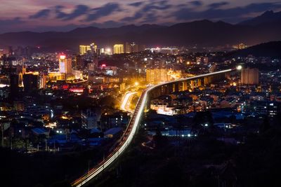 High angle view of illuminated cityscape against sky at night