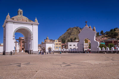 Group of people in front of building against clear blue sky